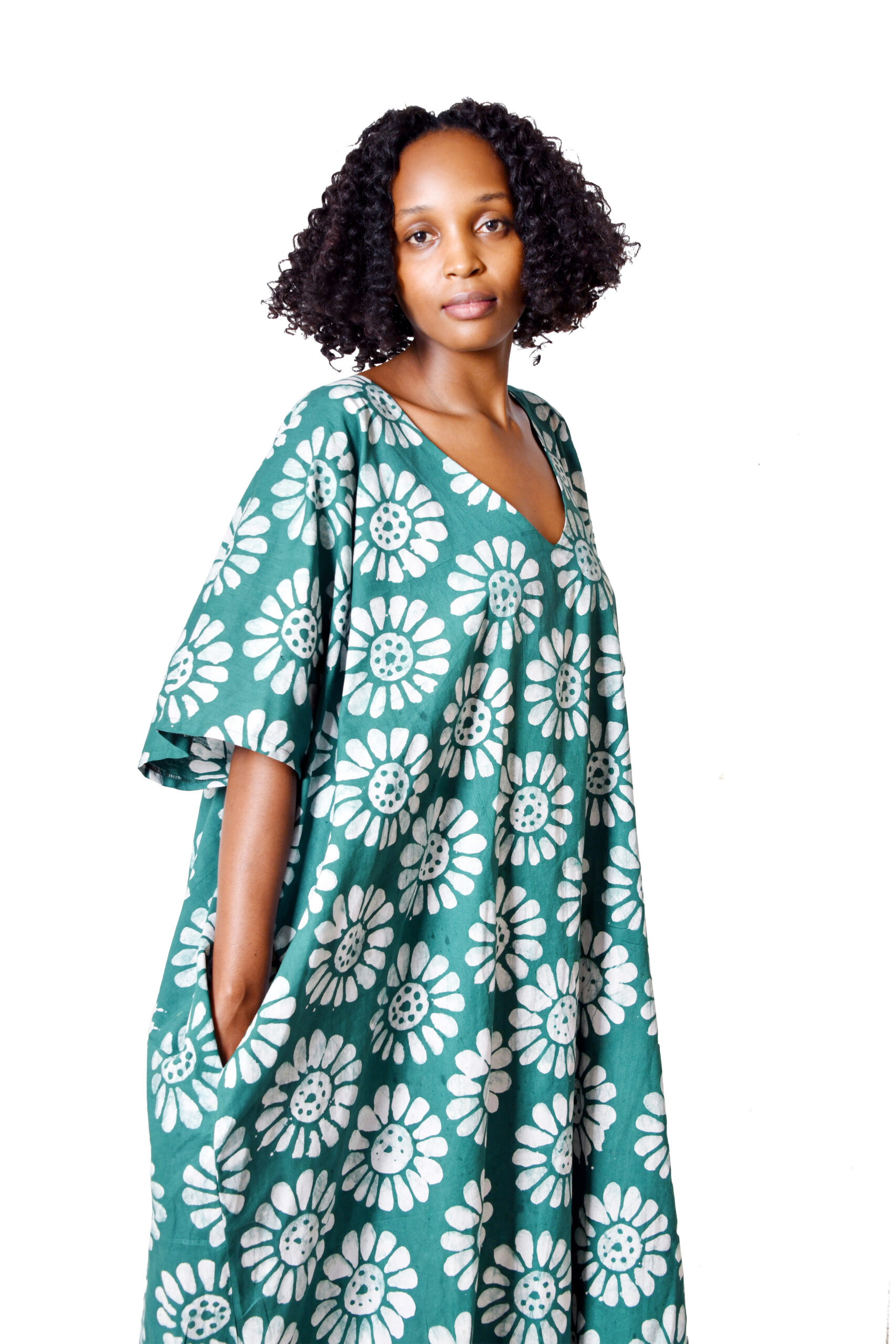 A model wearing a flowing V-neck full-length kaftan, showcasing handmade African fashion.
